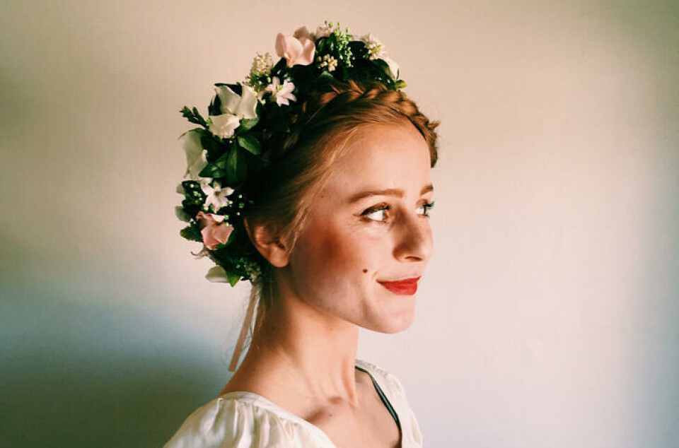 Med en vakker blomsterkrans på hodet, er du klar for enhver fest. Ung kvinne med blomsterkrans på hodet.